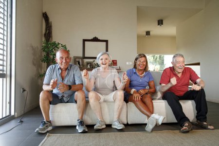 Téléchargez les photos : Groupe de personnes âgées heureuses à la maison regarder le football - en image libre de droit
