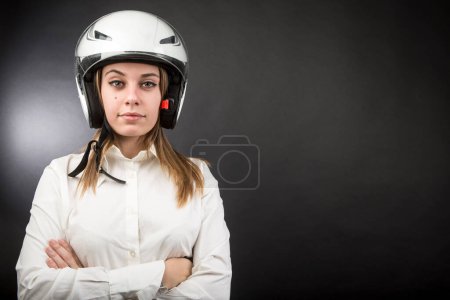Téléchargez les photos : Fille blonde avec casque de moto et chemise blanche isolé sur fond noir - en image libre de droit