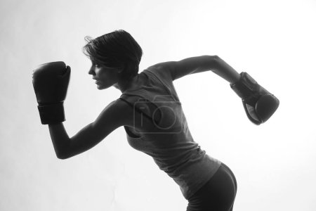 Foto de Hermosa chica con pelo bob y guantes de boxeo sostiene gurdia alta, aislado sobre fondo blanco, blanco y negro - Imagen libre de derechos