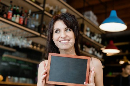 Photo for Smiling female barista holding tablet in cafe - Royalty Free Image