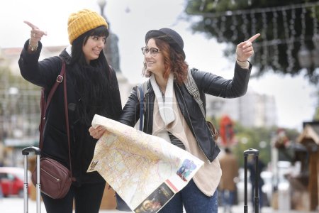 Foto de Mujeres jóvenes con mapa en la calle de la ciudad - Imagen libre de derechos