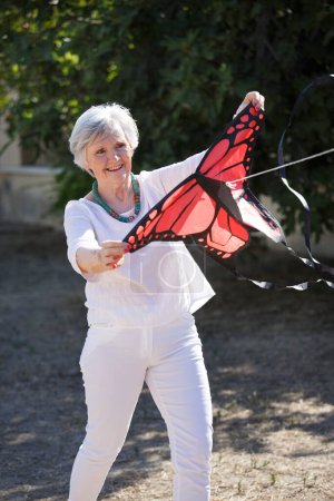 Téléchargez les photos : Senior femme tenant cerf-volant - en image libre de droit