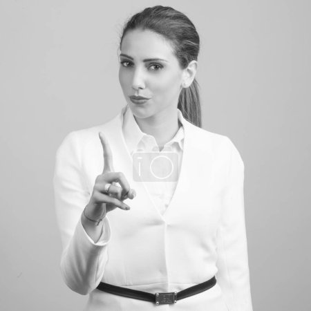 Téléchargez les photos : Studio plan de jeune belle femme d'affaires persane sur fond gris en noir et blanc - en image libre de droit