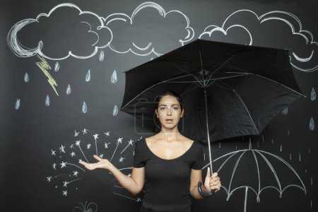 Téléchargez les photos : Femme tenant un parapluie vert isolé sur noir - en image libre de droit