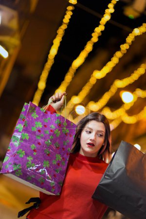 Téléchargez les photos : Belle femme aux cheveux bruns peints en violet autour des magasins pour faire du shopping - en image libre de droit