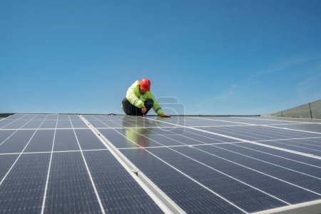 Téléchargez les photos : Homme travaillant sur le toit de panneaux solaires - en image libre de droit