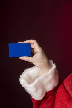 Photo for Woman holding a gift box on a blue background - Royalty Free Image