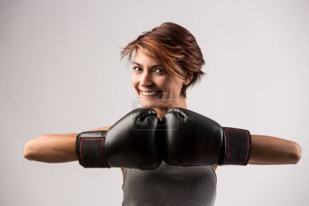 Photo for Beautiful girl with bob hair and boxing gloves holds gurdia high, isolated on white background - Royalty Free Image
