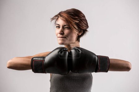 Foto de Hermosa chica con pelo bob y guantes de boxeo sostiene gurdia alta, aislado sobre fondo blanco - Imagen libre de derechos