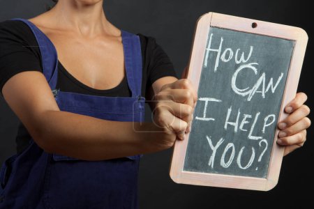 Téléchargez les photos : Femme mains tenant un tableau noir avec les mots "comment puis-je vous aider?" - en image libre de droit