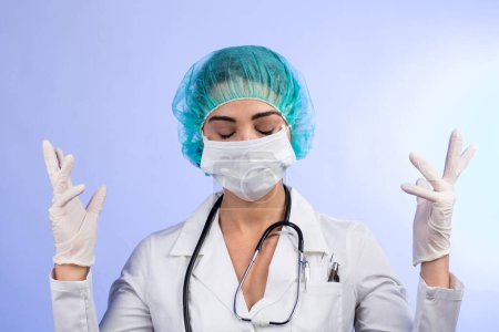 Téléchargez les photos : Médecin femme en manteau blanc, masque facial blanc, coiffure verte montre des gants en latex avant l'opération, isolé sur fond blanc - en image libre de droit