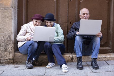 Foto de Personas mayores que usan computadoras portátiles al aire libre - Imagen libre de derechos