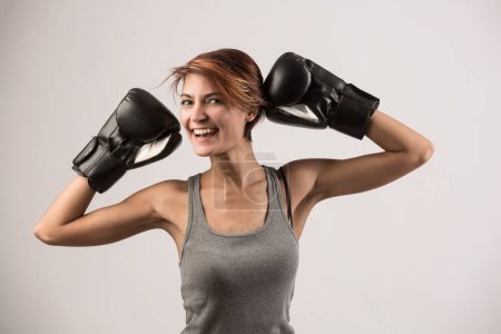 Foto de Hermosa chica con pelo bob y guantes de boxeo sostiene gurdia alta, aislado sobre fondo blanco - Imagen libre de derechos