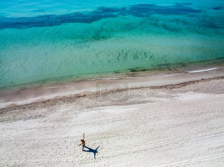 Foto de Vista aérea de una playa con mar cristalino - se ve a un hombre solitario mirando al mar. - Imagen libre de derechos
