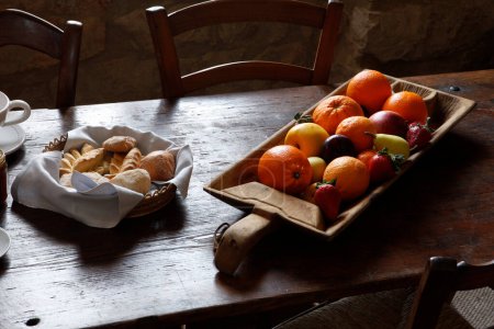 Téléchargez les photos : Fruits et pain sur plateaux dans un contexte traditionnel - en image libre de droit