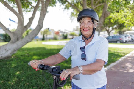 Photo for Senior woman in helmet using a bicycle - Royalty Free Image