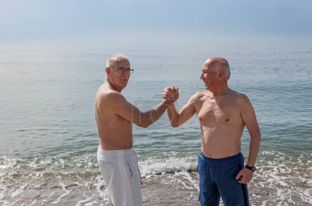 Photo for Two senior men exercising at the beach - Royalty Free Image