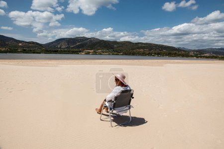 Foto de Mujer mayor en silla en la playa - Imagen libre de derechos
