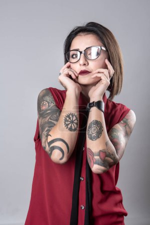 Foto de Retrato de una hermosa joven con tatuajes sobre fondo gris - Imagen libre de derechos