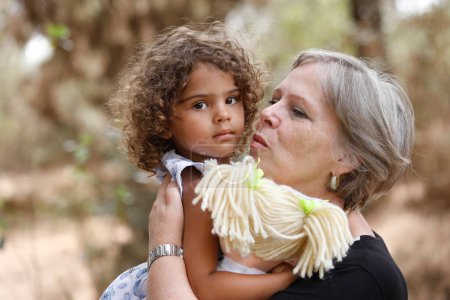 Téléchargez les photos : Portrait de petite-fille et grand-mère étreignant - en image libre de droit