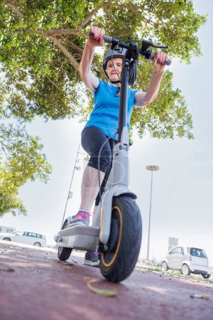 Photo for Senior woman with scooter riding in the park - Royalty Free Image