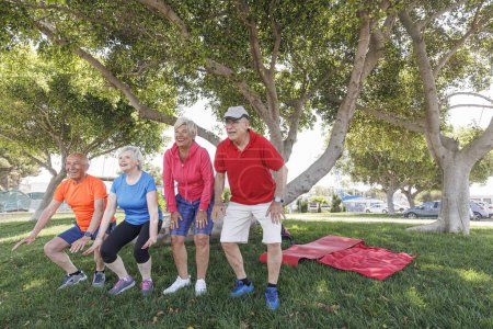 Téléchargez les photos : Groupe de personnes âgées faisant de l'exercice dans le parc - en image libre de droit