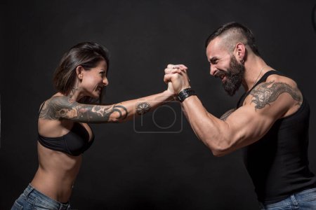 Photo for Happy tattooed couple on dark background - Royalty Free Image