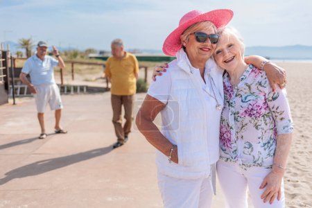 Foto de Mujer mayor con nieta en la playa - Imagen libre de derechos