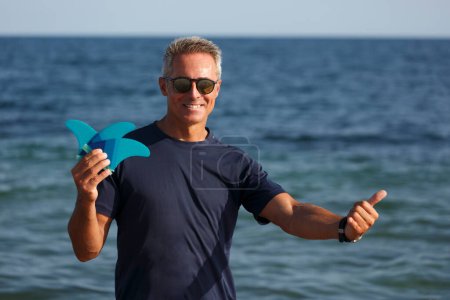 Téléchargez les photos : Homme avec des lunettes de soleil montre des éléments de Kitesurf - en image libre de droit