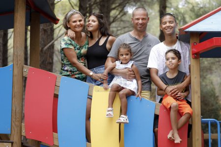 Téléchargez les photos : Belle Famille Multiethnique Italienne - Brésilienne se réunit à proximité dans un cadre naturel d'une pinède - en image libre de droit