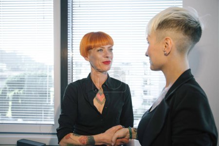 Photo for Young tattooed girls do business in the office - Royalty Free Image