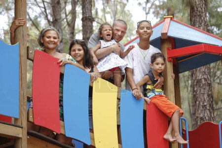 Téléchargez les photos : Belle Famille Multiethnique Italienne - Brésilienne se réunit à proximité dans un cadre naturel d'une pinède - en image libre de droit