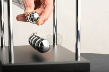 Téléchargez les photos : Newton berceau pendules en acier boules cinétiques main tirant un - en image libre de droit