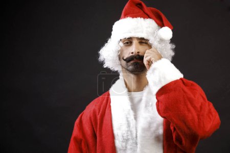 Photo for Santa claus adjusts his mustache, isolated on black background - Royalty Free Image