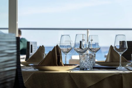 Téléchargez les photos : Mettre la table dans un restaurant près de la mer - en image libre de droit