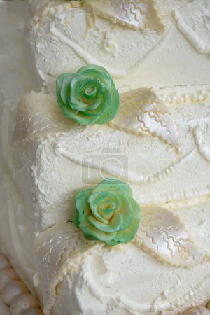 Foto de Detalle de pastel de boda crema blanca acabado con flores verdes - Imagen libre de derechos