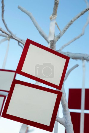 Photo for White place cards with red frame hanging on a tree - Royalty Free Image