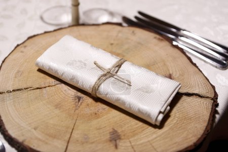 Photo for Creative decoration of napkin with cutlery over a tree trunk for important event - Royalty Free Image