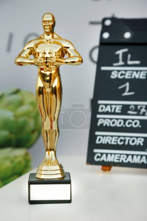 Foto de Primer plano de la estatuilla del Oscar y en el fondo la pizarra con los datos de una película - Imagen libre de derechos