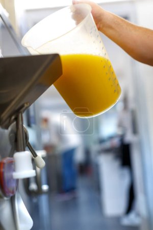 Téléchargez les photos : Détail de la cruche avec du jus d'orange versé sur une machine comme ingrédient - en image libre de droit