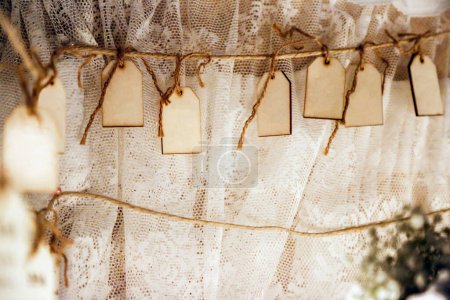 Foto de Etiquetas de cuerda de madera colgando en una cuerda en la ceremonia de la boda - Imagen libre de derechos