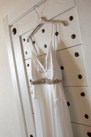 Foto de Vestido de novia colgando en percha en percha. - Imagen libre de derechos