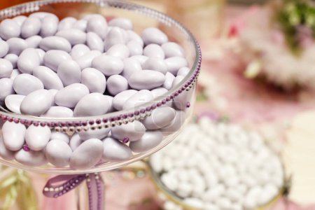 Photo for Table with delicious variegated sugared almonds elegantly displayed - Royalty Free Image