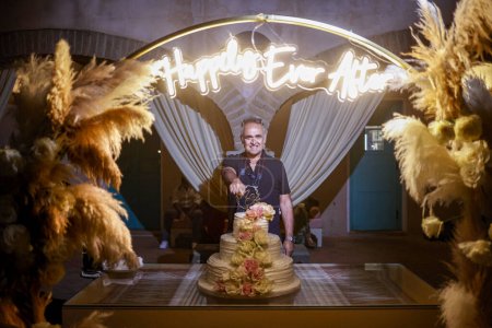 Téléchargez les photos : Homme heureux posant près gâteau de mariage - en image libre de droit