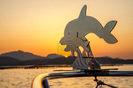 Téléchargez les photos : Figurines de dauphins métalliques sur un bateau - en image libre de droit