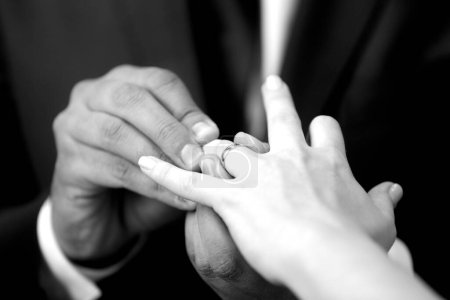 Foto de Novio poniendo un anillo de bodas en el dedo de la novia - Imagen libre de derechos