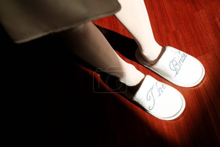 Téléchargez les photos : Pantoufles portées par une future mariée avec les mots "La mariée" - en image libre de droit