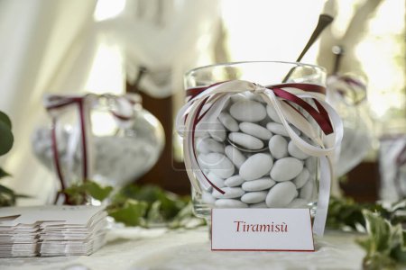 Photo for Table with delicious variegated sugared almonds elegantly displayed, table with candies at wedding reception - Royalty Free Image