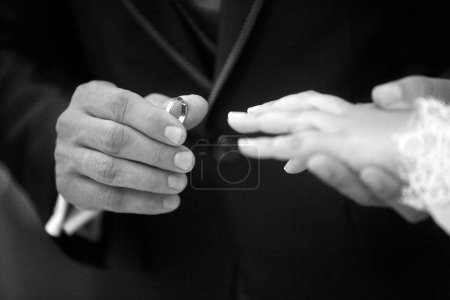 Photo for Groom putting on the bride 's hand on the finger. - Royalty Free Image