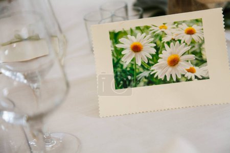 Téléchargez les photos : Carte de mariage avec bouquet de marguerites sur la table - en image libre de droit